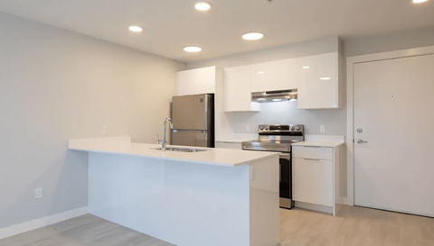 a kitchen with an island and a stainless steel refrigerator