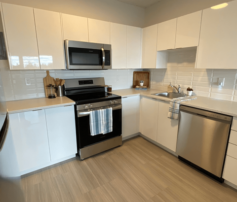 A modern kitchen with white cabinets and stainless steel appliances.