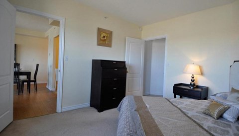 a bedroom with a bed and a dresser    and a dining room