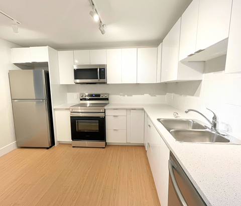 A kitchen with white cabinets and stainless steel appliances.