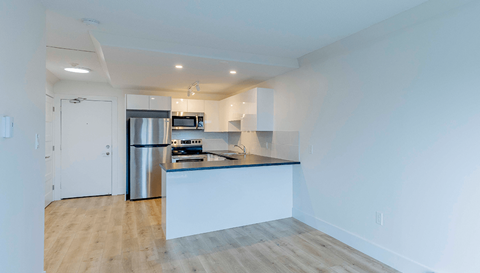 A kitchen with a white island and stainless steel appliances.