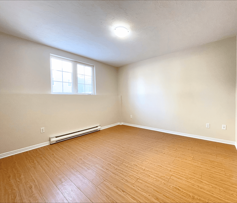A room with a window and a radiator on the wall.