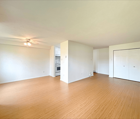 A room with wooden floors and a ceiling fan.
