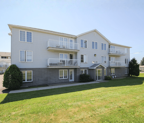 A large two-story apartment building with a balcony on the second floor.