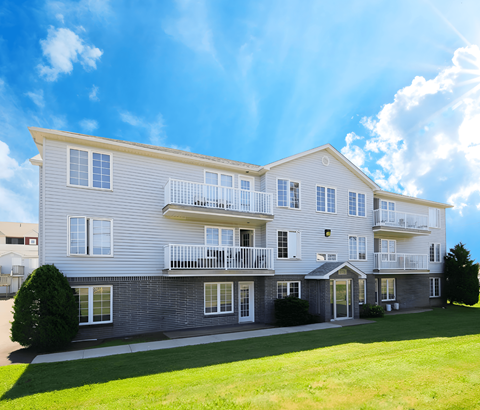 A large, multi-story residential building with a balcony on the second floor.