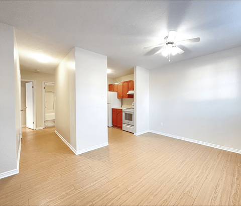 A room with a ceiling fan and wooden flooring.