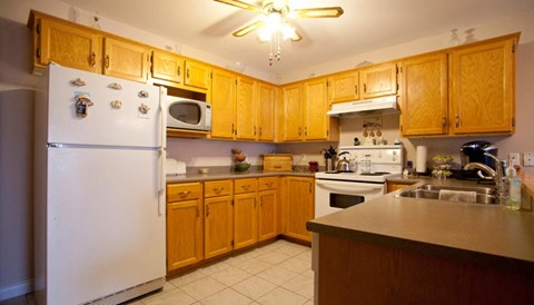 A kitchen with wooden cabinets and a white refrigerator.