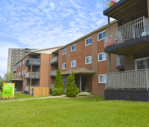 Apartment building with a sign in front that says 294-300.