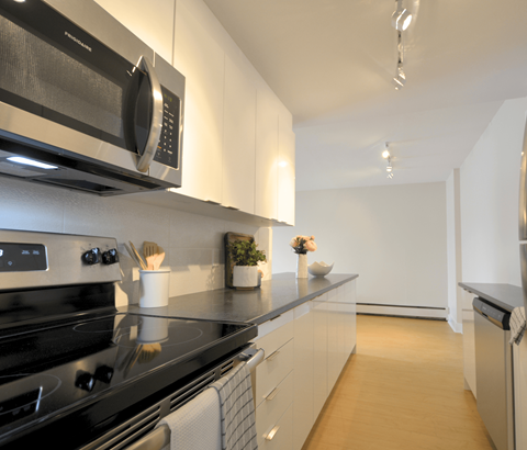 A modern kitchen with a black stove top oven and a black microwave above it.