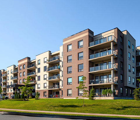 A row of modern apartment buildings with balconies and windows.