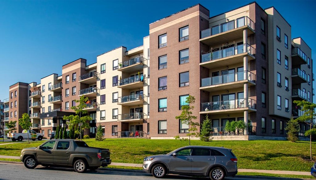 an apartment building with cars parked in front of it