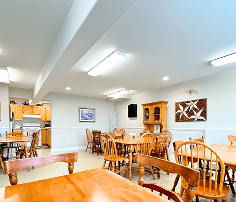 A dining room with wooden chairs and tables.