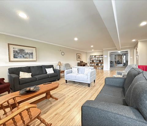 A living room with a grey couch, a wooden coffee table, and a painting on the wall.