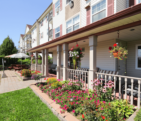 A building with a flower garden in front.