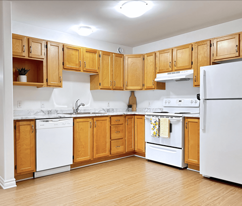 A kitchen with wooden cabinets and white appliances.