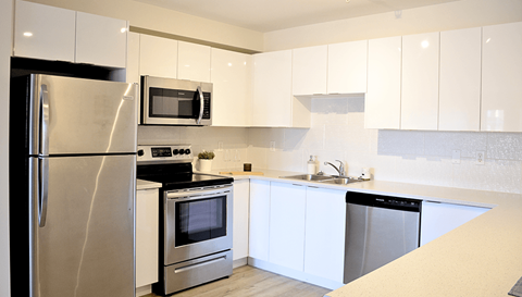 A modern kitchen with stainless steel appliances and white cabinets.