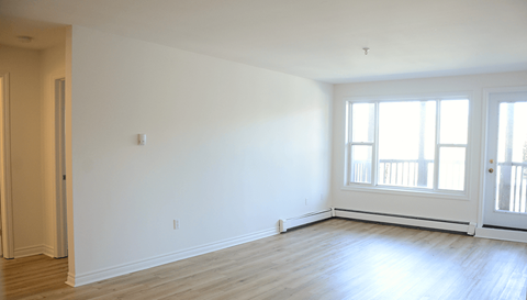 A large empty room with a door and a window.