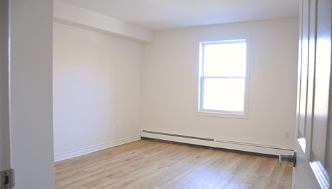 A room with a window and a radiator on the wall.