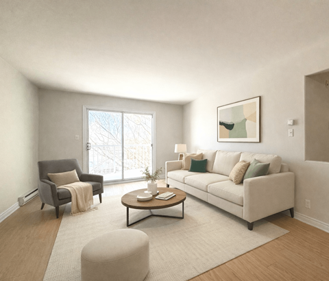 A living room with a grey armchair, a white sofa, a coffee table, and a large window.