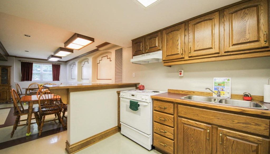 A kitchen with wooden cabinets and a white dishwasher.