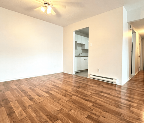 A room with wooden flooring and a ceiling fan.