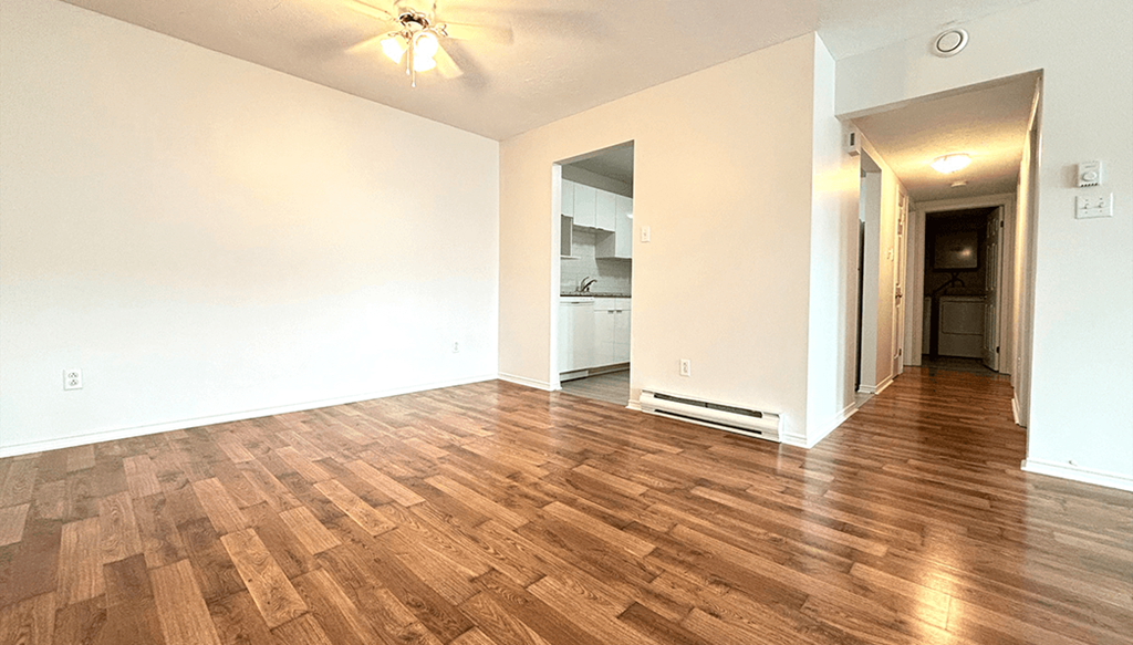 the living room and dining room of an empty house with wood floors