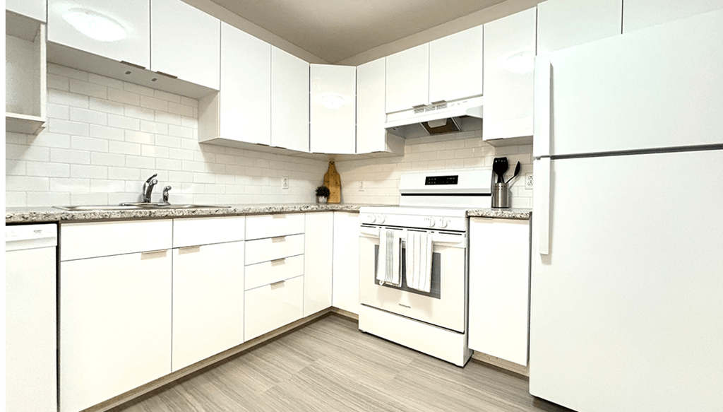 a white kitchen with white appliances and white cabinets
