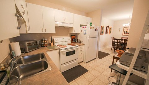 A kitchen with white appliances and wooden cabinets.