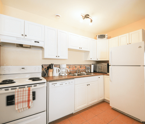 A kitchen with white appliances and cabinets.