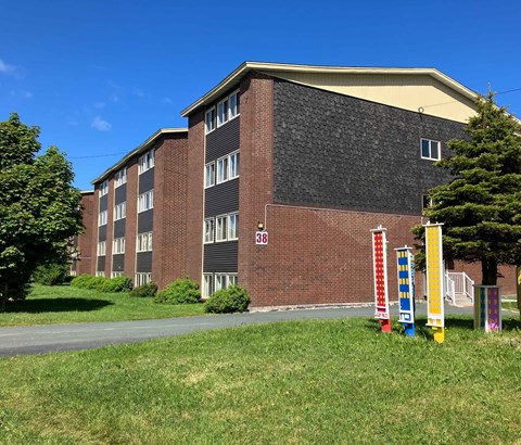 A red brick building with a black roof and a number 38 on the front.