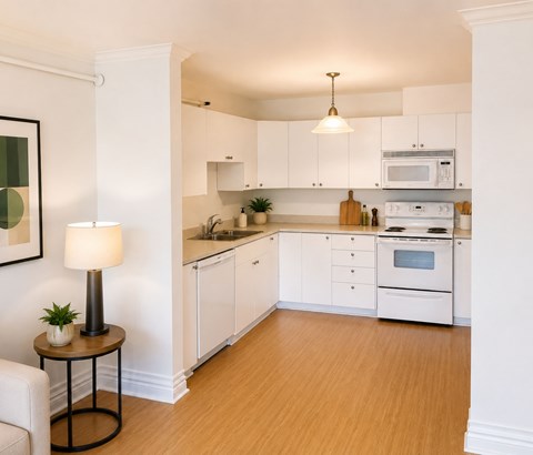 A well-lit kitchen with white cabinets and wooden flooring.