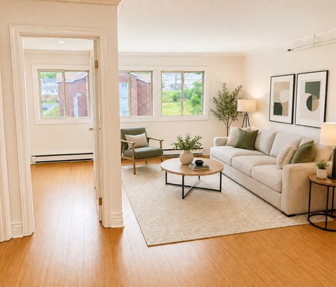 A living room with a white couch, a green chair, and a coffee table.
