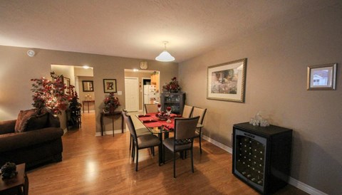 A living room with a Christmas tree and a dining table set for six.