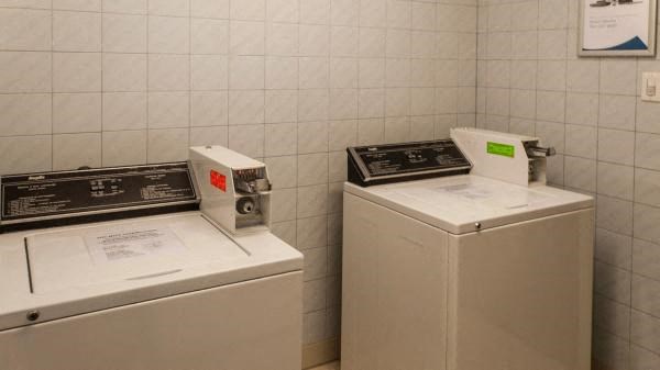 two washing machines in a room with a tiled wall