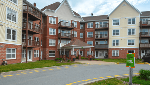 an exterior view of an apartment building on a street