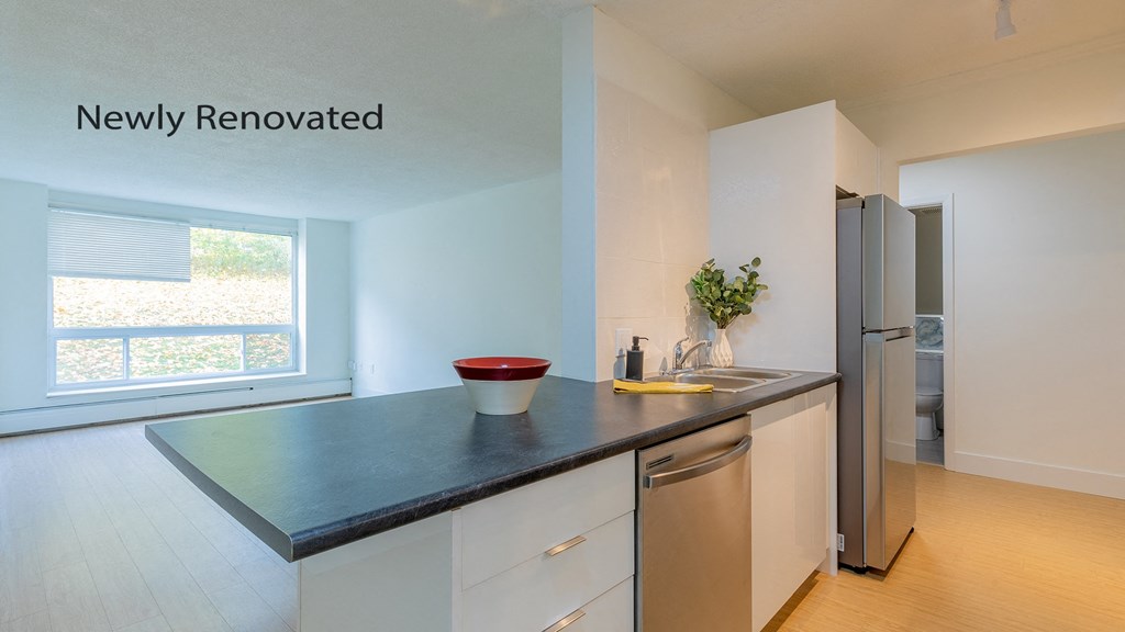 a kitchen with a counter top and a stainless steel refrigerator