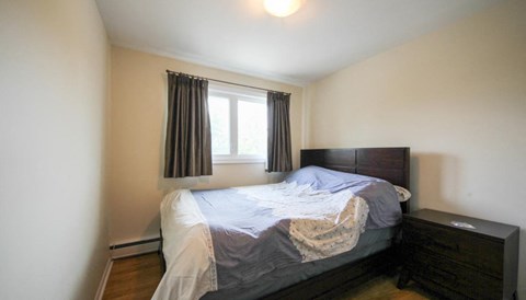 a small bedroom with a bed and a window