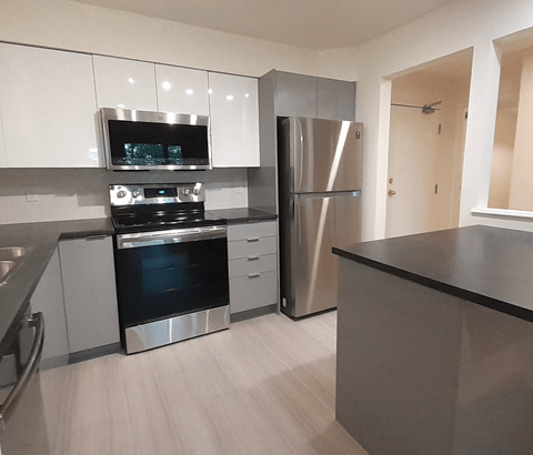 A modern kitchen with stainless steel appliances and white cabinets.