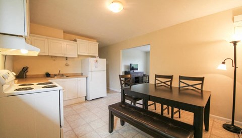 a kitchen and dining room with a table and chairs