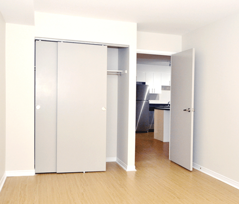 A white door is open to a kitchen.