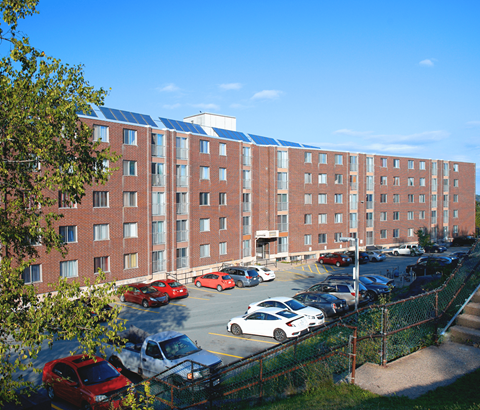 A parking lot in front of a red brick building.