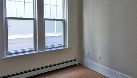 A room with a window and a wall socket.