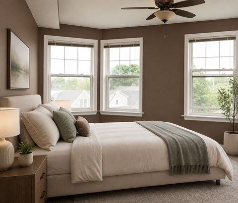 A bedroom with a large bed and a ceiling fan.