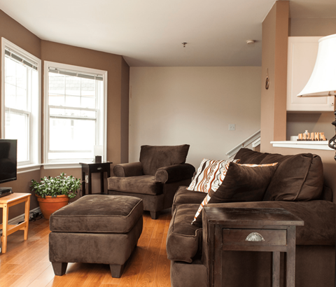 A living room with brown furniture and a flat screen TV.