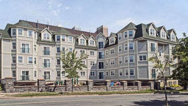 A large, multi-story residential building with a mix of window styles and balconies.