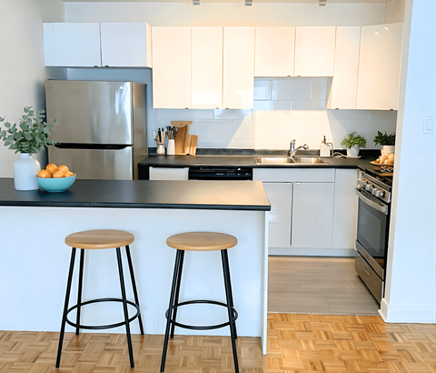 A kitchen with a black countertop and white cabinets.