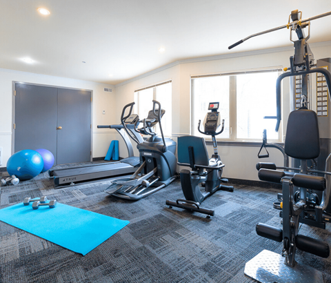 A gym with a variety of equipment including treadmills, exercise bikes, and weight machines.
