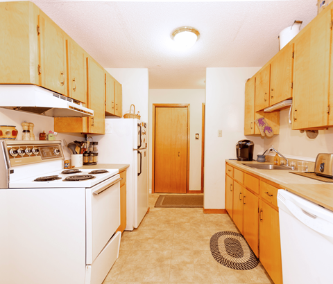A kitchen with wooden cabinets and white appliances.