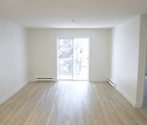 A room with a sliding glass door leading to a balcony.