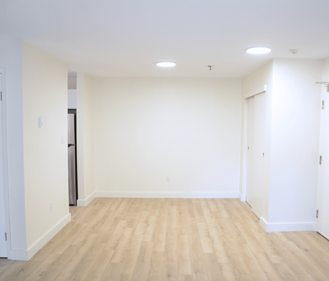 A room with wooden flooring and white walls.